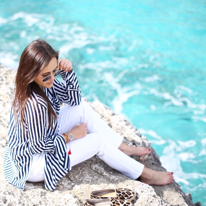 Bild auf Klippen, gestreifte Bluse, weiße Hose, Sonnenbrille